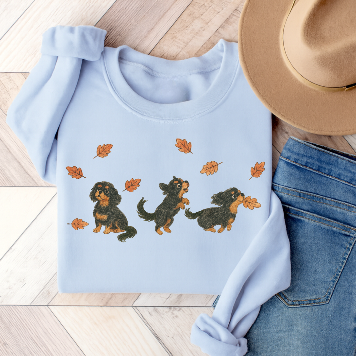 Black Tan Cavalier Chasing Leaves Sweatshirt Light Blue